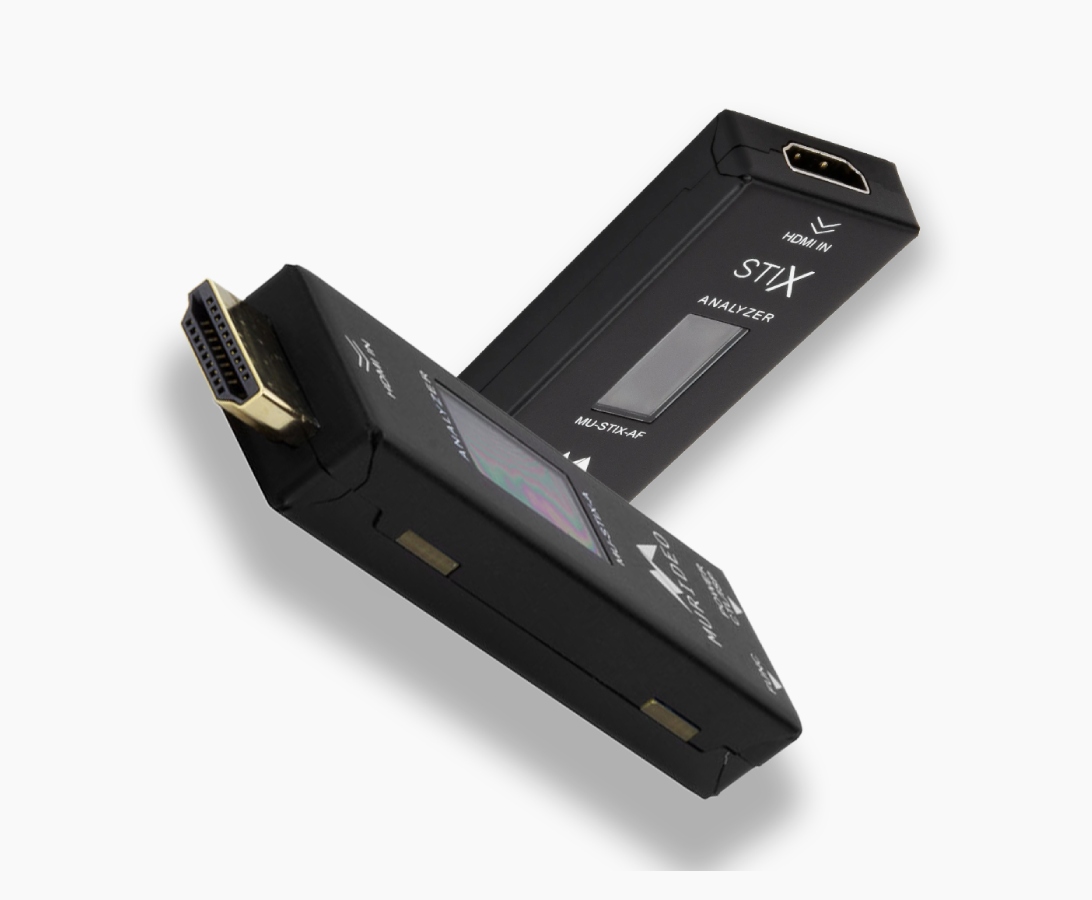 Two black electronic devices labeled "STIX ANALYZER" with HDMI and SCART connectors, used for signal analysis.