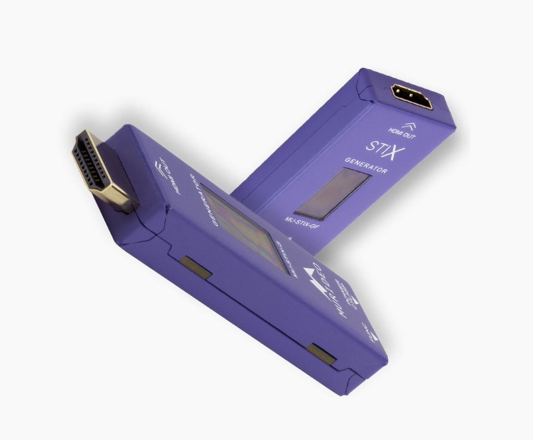 Two purple electronic devices with HDMI and SCART connectors, labeled "STX Generator," are shown against a white background.