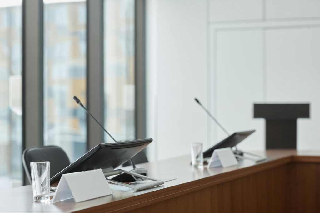 Premium conference room with retractable microphones and monitors showcasing modern boardroom technology