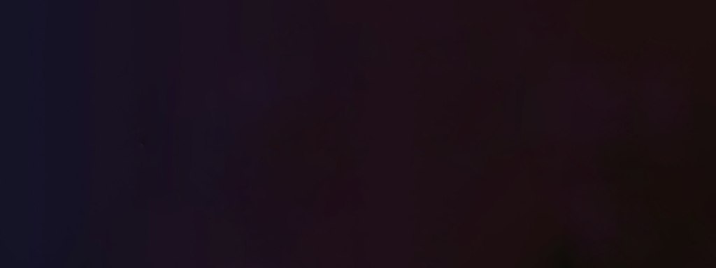 A dark, nearly black background with subtle shades of deep purple and brown. The image contains no discernible objects or features.