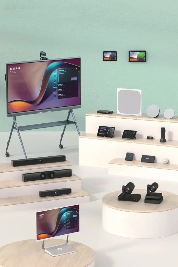 A display of various electronic devices and smart home gadgets, including TVs, speakers, cameras, and control panels, arranged on platforms against a light green wall.