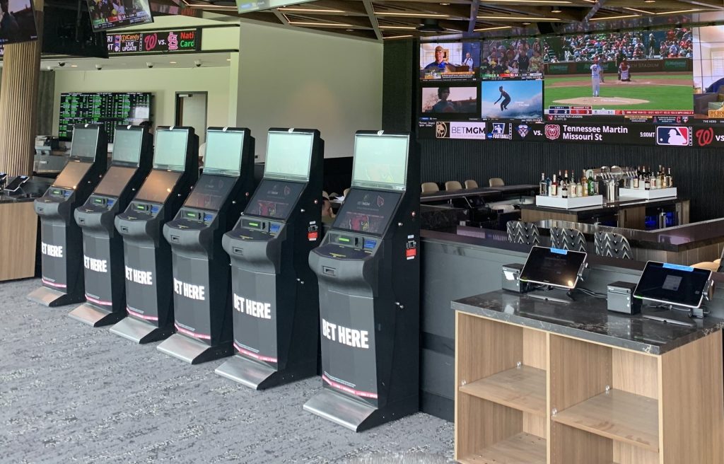 BetMGM Sportsbook interior at State Farm Stadium showing the 12-metre Barco LED video wall and betting kiosks powered by ZeeVee ZyPer4K SDVoE AV over IP distribution